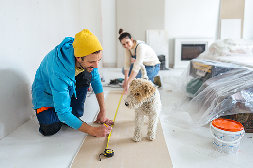 Paar mit Hund misst Fläche ab